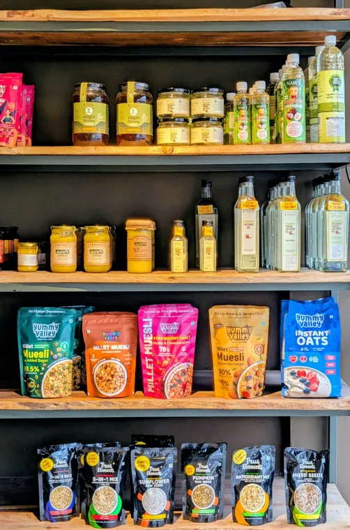 Shelves of cold-pressed coconut oil, A2 ghee, Nilgiri honey and millet muesli